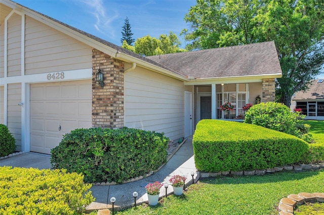 ranch-style home with brick siding, a shingled roof, and an attached garage