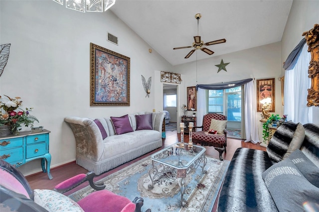 living room featuring lofted ceiling, baseboards, visible vents, ceiling fan, and wood finished floors