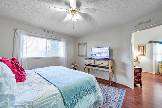 bedroom with a textured ceiling, a ceiling fan, and wood finished floors