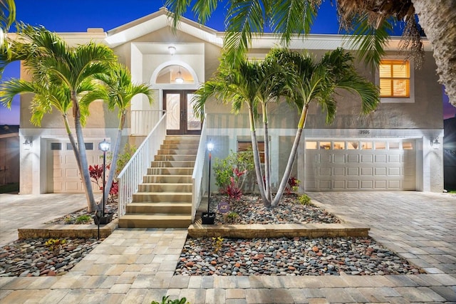 view of front of home featuring stucco siding, french doors, and decorative driveway