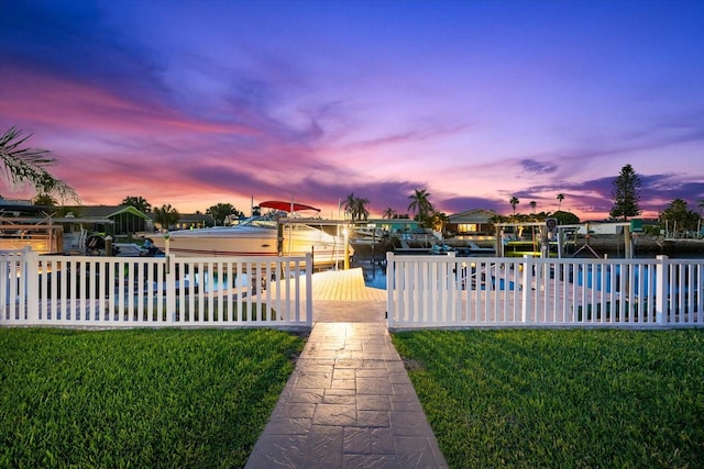 view of yard featuring a dock, an outdoor pool, fence, and boat lift