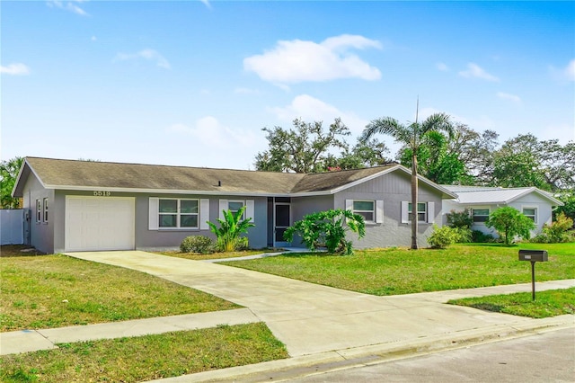 5519 Homewood Dr, Sarasota, FL 34232 - ranch-style house featuring driveway, stucco siding, a garage, and a front lawn
