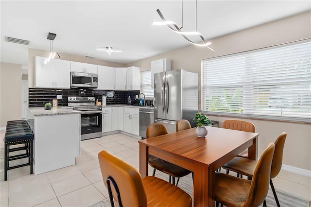 5519 Homewood Dr, Sarasota, FL 34232 - kitchen with light tile patterned floors, visible vents, appliances with stainless steel finishes, light countertops, and decorative backsplash