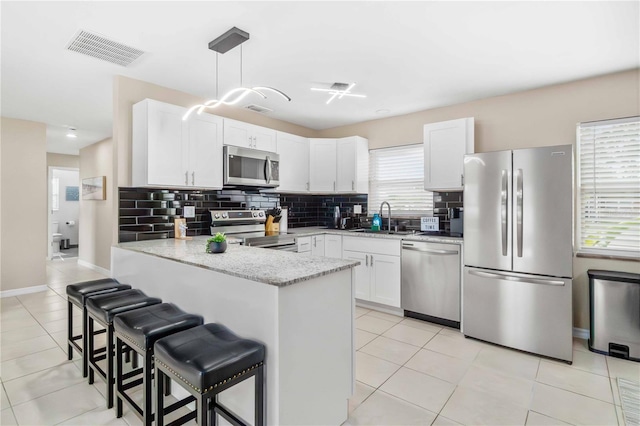 5519 Homewood Dr, Sarasota, FL 34232 - kitchen featuring visible vents, a sink, a breakfast bar, a peninsula, and stainless steel appliances