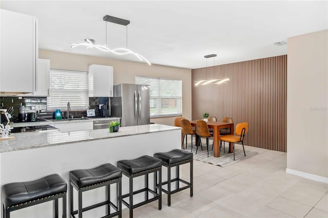 5519 Homewood Dr, Sarasota, FL 34232 - kitchen featuring stainless steel appliances, a peninsula, a breakfast bar, and a healthy amount of sunlight