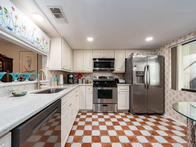 2555 Royal Pines Cir Unit A, Clearwater, FL 33763 - kitchen featuring stainless steel appliances, light countertops, light flooring, white cabinets, and wallpapered walls