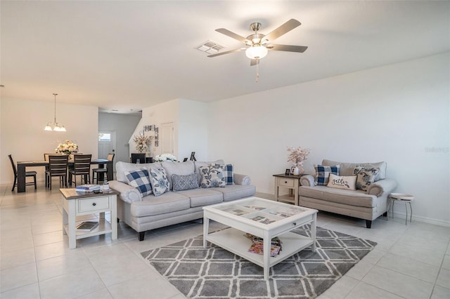 living room featuring baseboards, ceiling fan with notable chandelier, visible vents, and light tile patterned floors