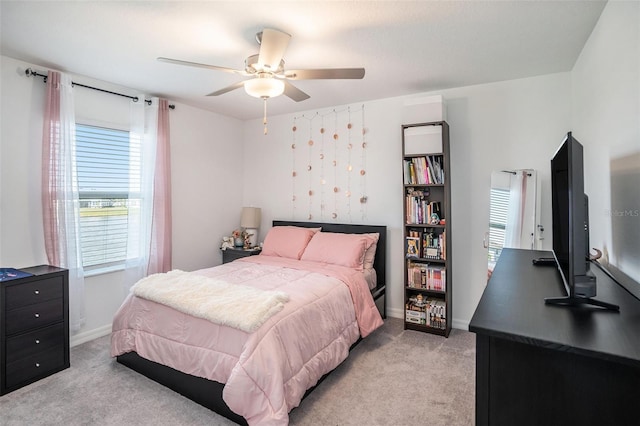 bedroom featuring ceiling fan, baseboards, and light colored carpet