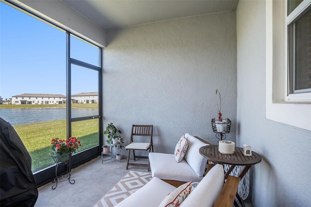 sunroom / solarium featuring a water view and a residential view