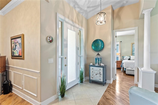 entryway with a healthy amount of sunlight, light wood finished floors, and ornate columns
