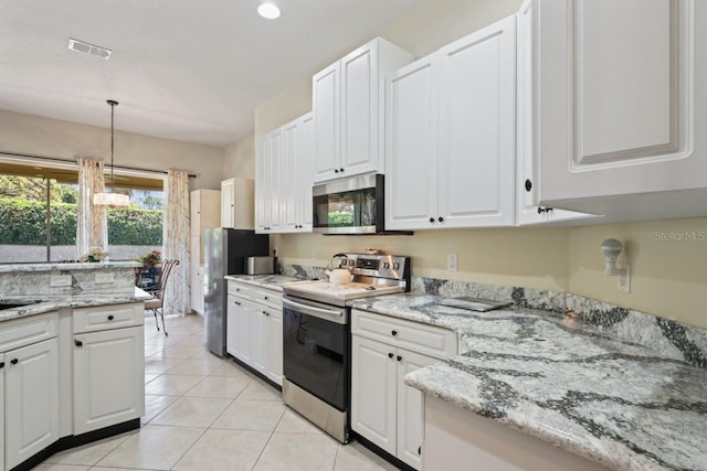 kitchen with white cabinets, visible vents, light tile patterned floors, pendant lighting, and appliances with stainless steel finishes