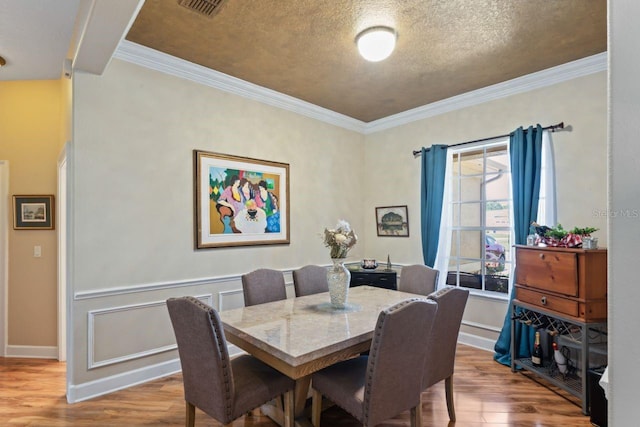 dining area with baseboards, wood finished floors, and ornamental molding