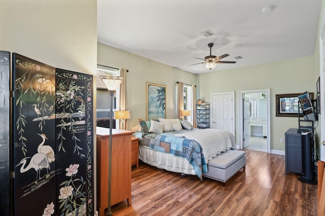 bedroom with baseboards, visible vents, wood finished floors, ceiling fan, and connected bathroom