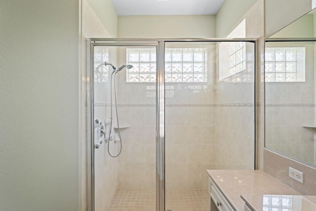 full bathroom with plenty of natural light, vanity, and a stall shower