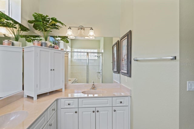 full bathroom with double vanity, a stall shower, and a sink