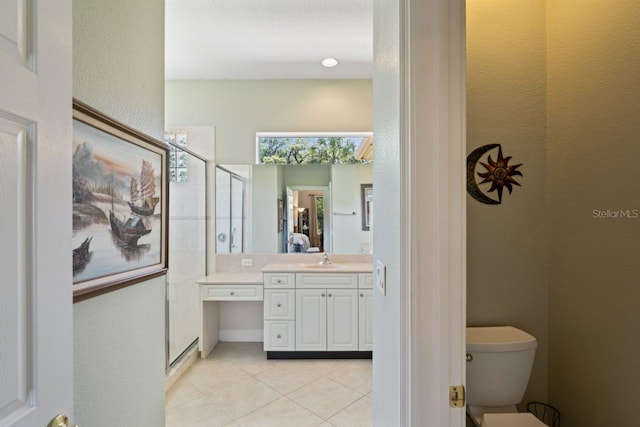 full bath featuring tile patterned floors, toilet, a shower stall, a textured wall, and vanity