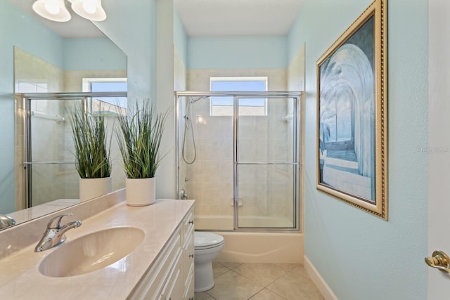 full bathroom with tile patterned floors, vanity, baseboards, enclosed tub / shower combo, and toilet