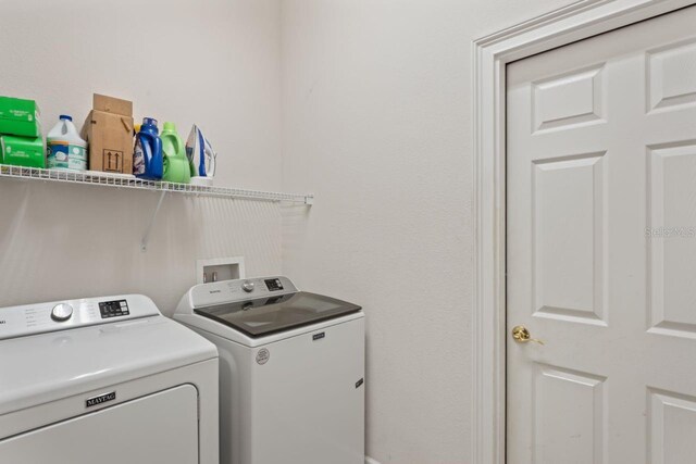 washroom with washing machine and clothes dryer and laundry area