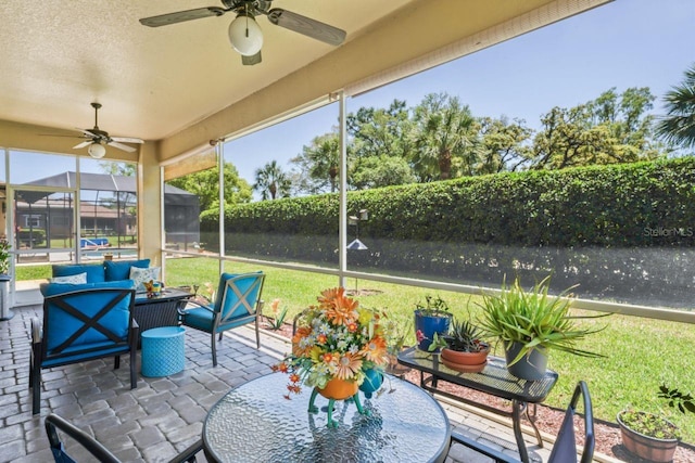 sunroom featuring an outdoor living space, a ceiling fan, and outdoor dining space