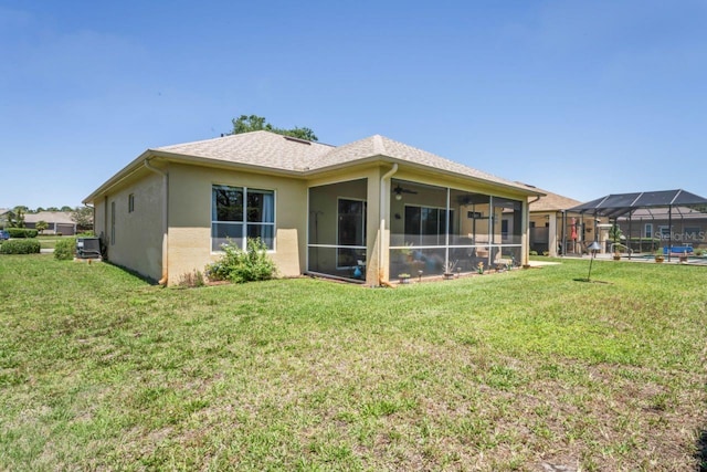 rear view of house with a yard, central air condition unit, stucco siding, ceiling fan, and a sunroom