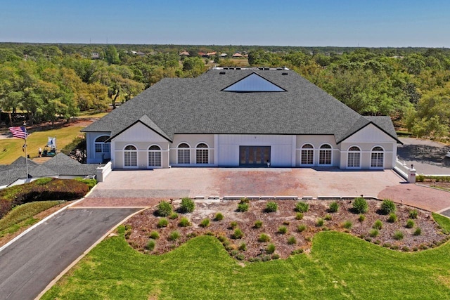 view of front of house featuring a front lawn and a forest view