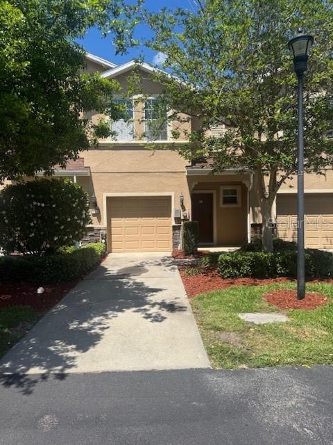 778 Spring Flowers Trl, Brandon, FL 33511 - view of front of property with stucco siding, concrete driveway, and an attached garage