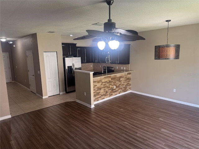 778 Spring Flowers Trl, Brandon, FL 33511 - kitchen with wood finished floors, appliances with stainless steel finishes, backsplash, a ceiling fan, and a peninsula