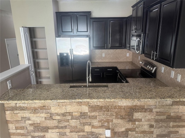 778 Spring Flowers Trl, Brandon, FL 33511 - kitchen with stone counters, dark cabinets, appliances with stainless steel finishes, and a sink