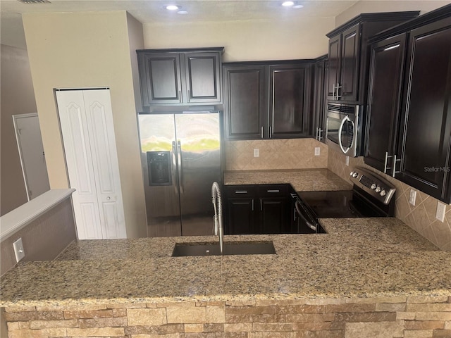 778 Spring Flowers Trl, Brandon, FL 33511 - kitchen with recessed lighting, a sink, decorative backsplash, light stone counters, and appliances with stainless steel finishes