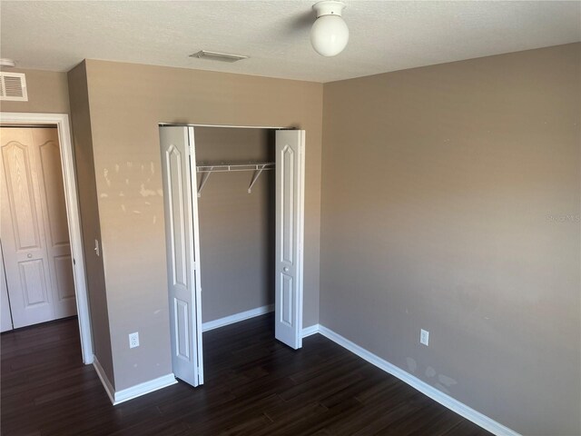 778 Spring Flowers Trl, Brandon, FL 33511 - unfurnished bedroom featuring dark wood-style floors, visible vents, a closet, and baseboards