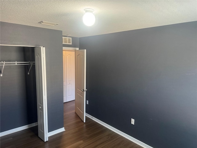 778 Spring Flowers Trl, Brandon, FL 33511 - unfurnished bedroom with a closet, visible vents, baseboards, a textured ceiling, and wood finished floors