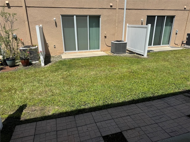 778 Spring Flowers Trl, Brandon, FL 33511 - rear view of house with a lawn, cooling unit, and stucco siding