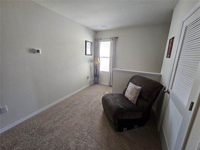 living area with baseboards, carpet flooring, and a textured ceiling