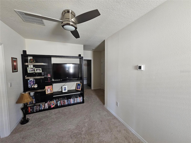 living area with a textured ceiling, baseboards, visible vents, a ceiling fan, and carpet floors