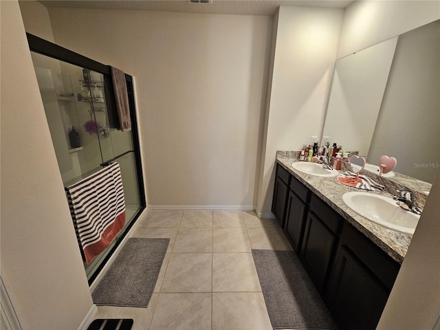 bathroom featuring double vanity, tile patterned floors, a stall shower, and a sink