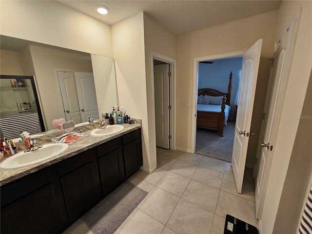 full bathroom featuring tile patterned flooring, baseboards, a sink, and double vanity