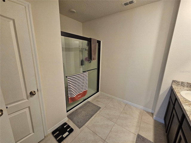 full bath with a textured ceiling, a stall shower, baseboards, visible vents, and vanity