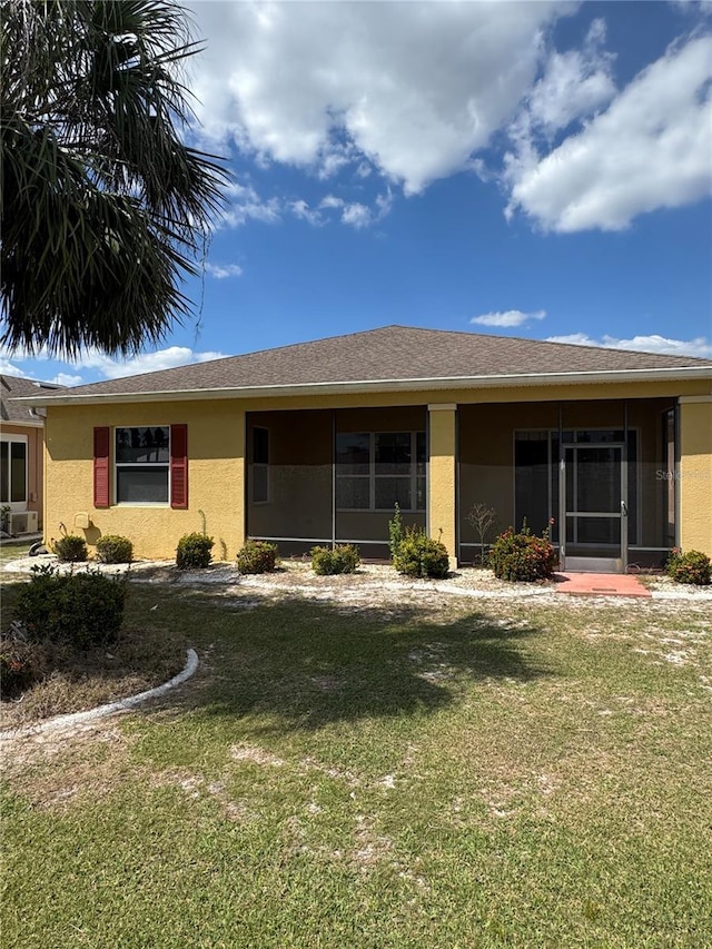 446 Noble Faire Dr, Sun City Center, FL 33573 - back of property with stucco siding, a lawn, and a sunroom