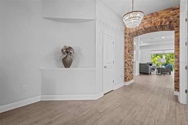 15329 Renaissance Ave, Odessa, FL 33556 - hallway featuring arched walkways, wood finished floors, baseboards, and a notable chandelier