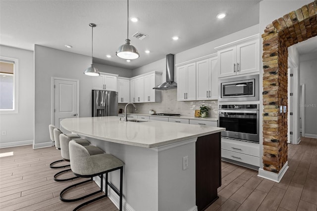 15329 Renaissance Ave, Odessa, FL 33556 - kitchen with wood finished floors, a sink, stainless steel appliances, wall chimney exhaust hood, and visible vents
