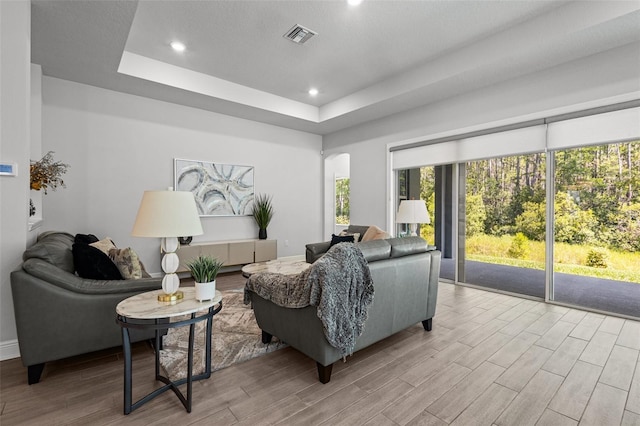 15329 Renaissance Ave, Odessa, FL 33556 - living room featuring a tray ceiling, wood finished floors, visible vents, and recessed lighting