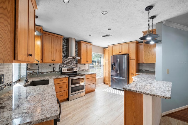 kitchen featuring backsplash, visible vents, a sink, wall chimney exhaust hood, and appliances with stainless steel finishes
