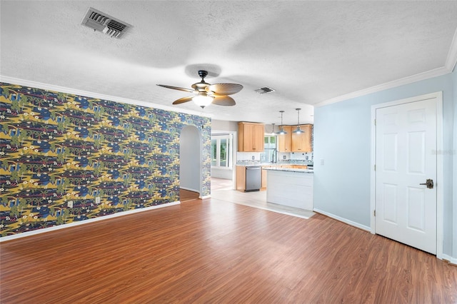 unfurnished living room featuring light wood-style flooring, a textured ceiling, baseboards, visible vents, and ceiling fan