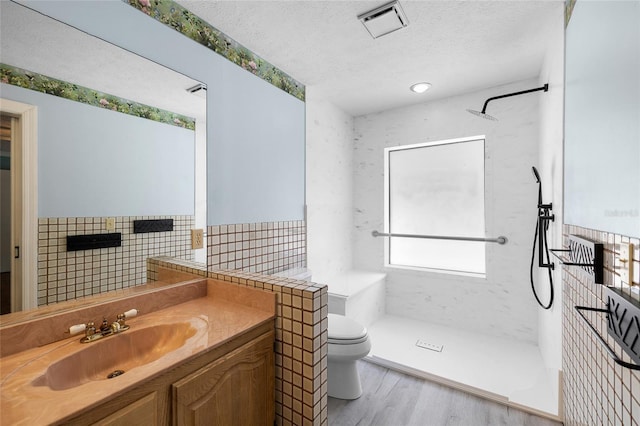 full bath featuring wood finished floors, visible vents, toilet, a walk in shower, and a textured ceiling