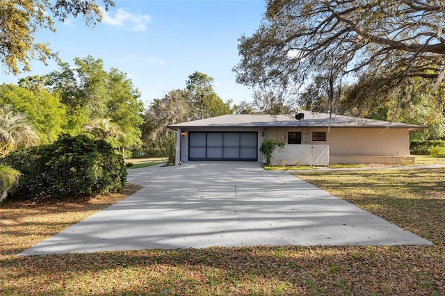 view of front of property featuring stucco siding, driveway, and a garage