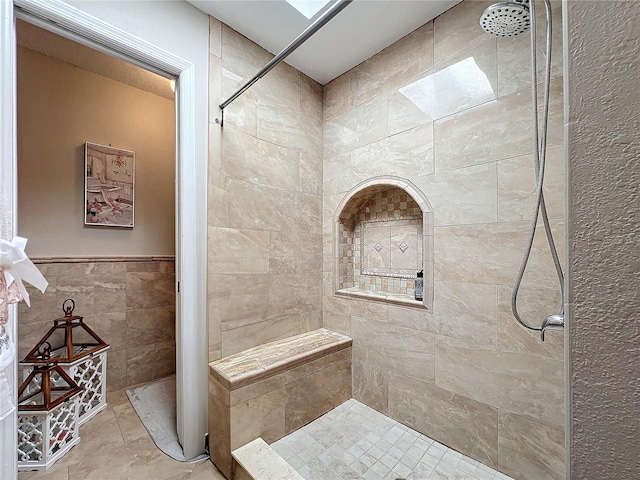 16819 Stanza Ct, Tampa, FL 33624 - bathroom with a tile shower, tile walls, and wainscoting