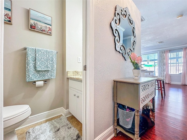 16819 Stanza Ct, Tampa, FL 33624 - interior space with wood finished floors, visible vents, toilet, vanity, and baseboards