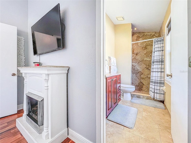 16819 Stanza Ct, Tampa, FL 33624 - full bathroom with baseboards, vanity, toilet, and a stall shower