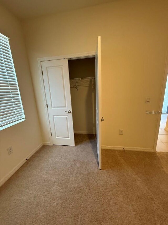 7937 Wheat Stone Dr, Zephyrhills, FL 33540 - unfurnished bedroom with light carpet, a closet, and baseboards