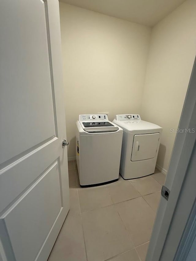 7937 Wheat Stone Dr, Zephyrhills, FL 33540 - laundry area with independent washer and dryer, light tile patterned flooring, and baseboards